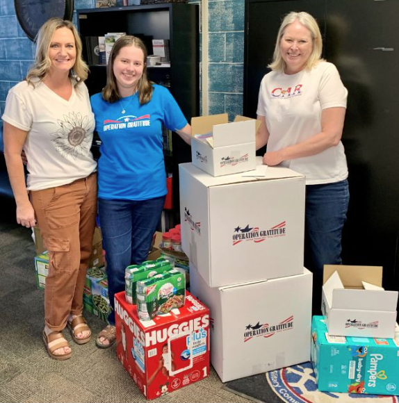 Volunteers with stacked Operation Gratitude care packages
