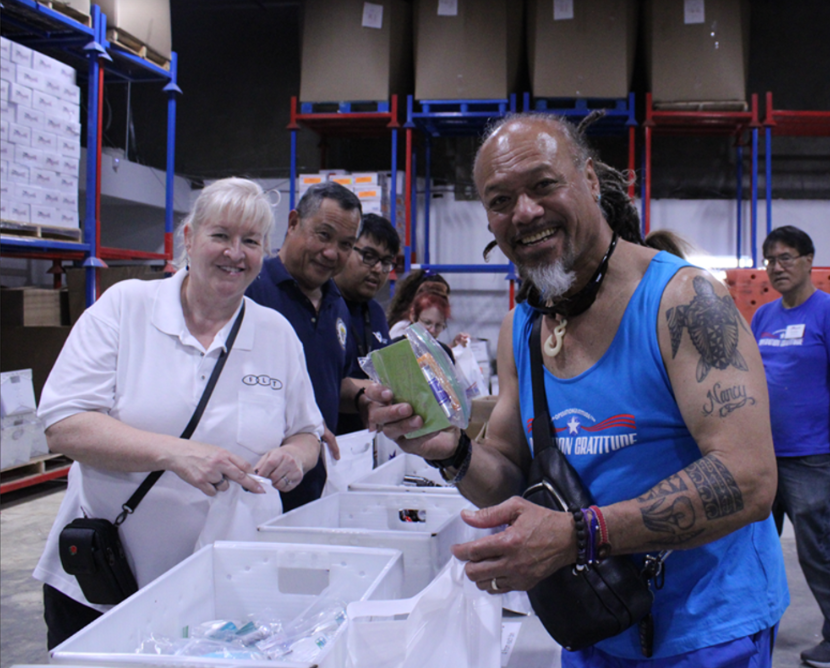 Smiling volunteers packing care package items
